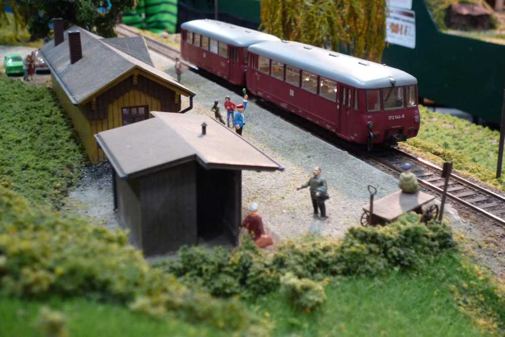 Roter Schienenbus am kleinen Bahnhof einer Ausstellungsanlage, Modell Hobby Spiel Leipzig