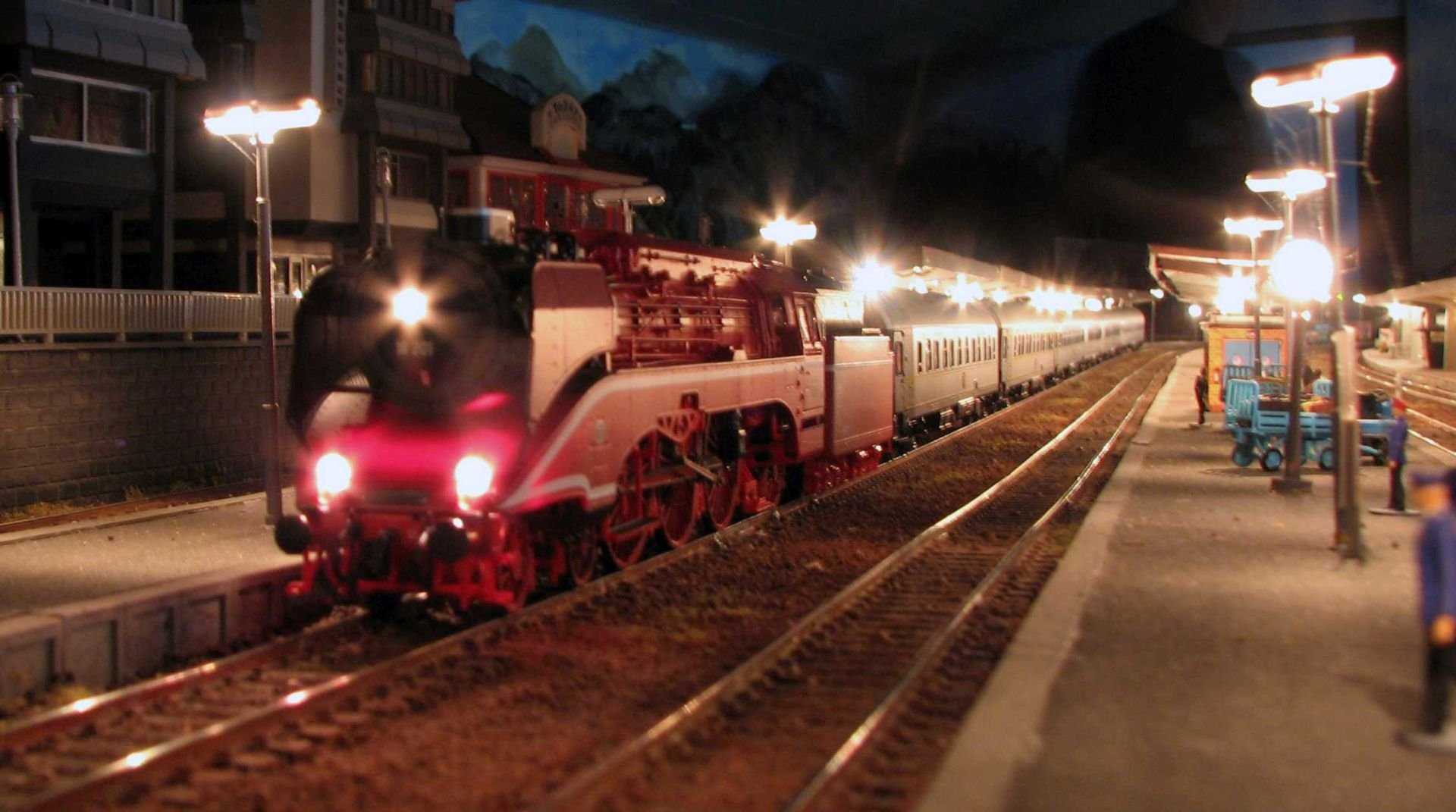 Dampflok mit Nachtzug im beleuchteten Bahnhof der Vereinsanlage